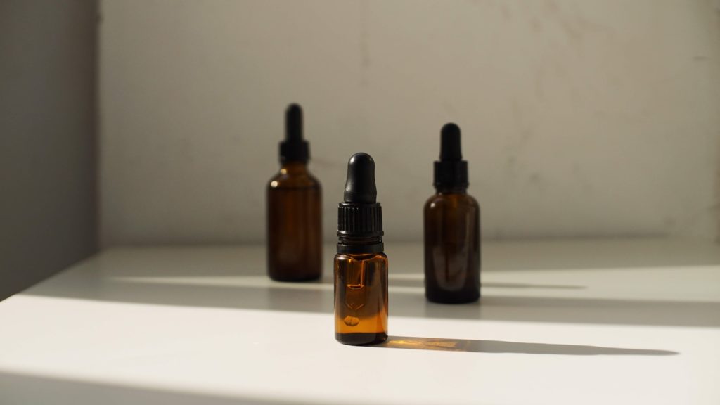 three bottles of essential oils sitting on a shelf